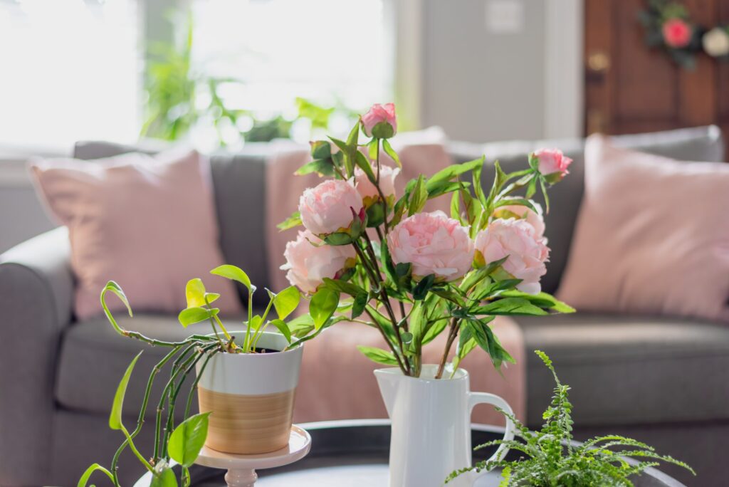 Living room decor with pink pillows and floral arrangement for new homeowners