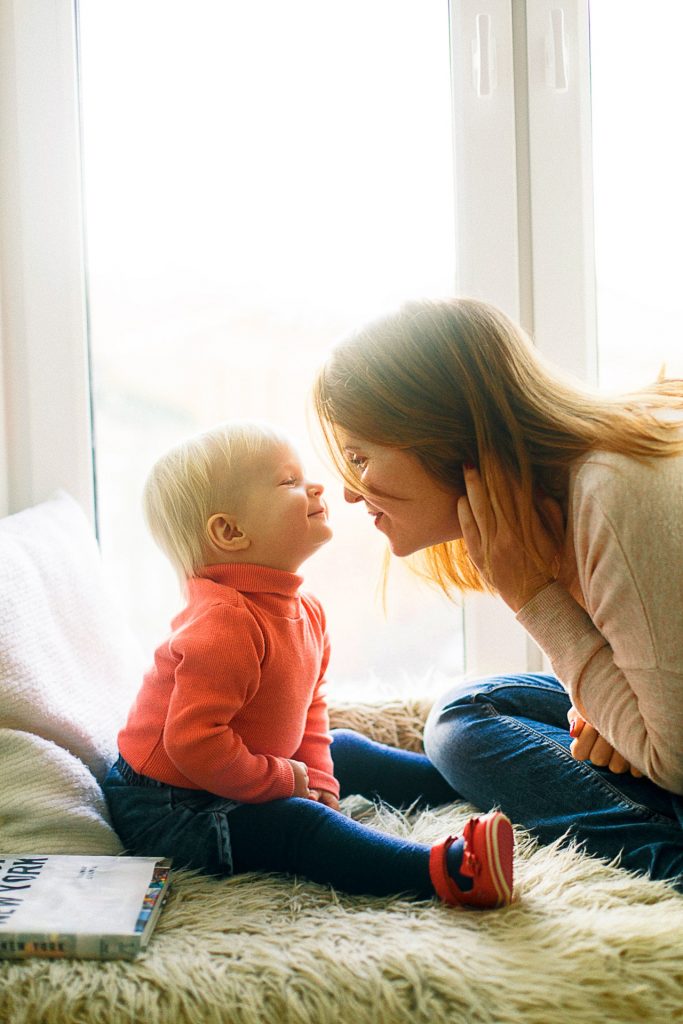 a person and a baby sitting on the floor