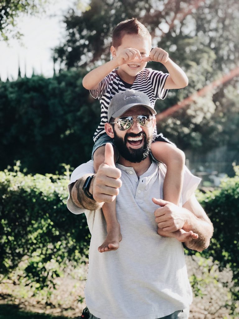 a person carrying a baby on the shoulders