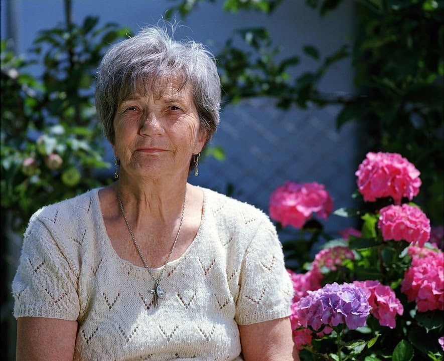 an old woman with a flower garden