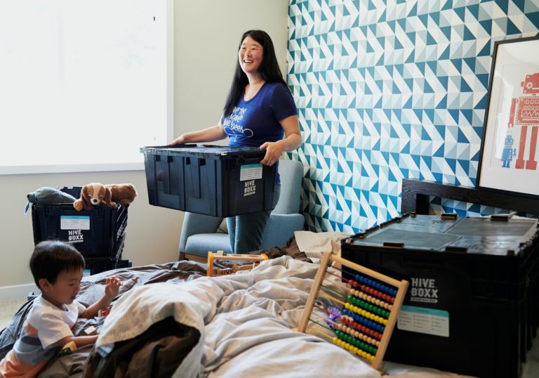 a person and a boy in a room with a computer and books