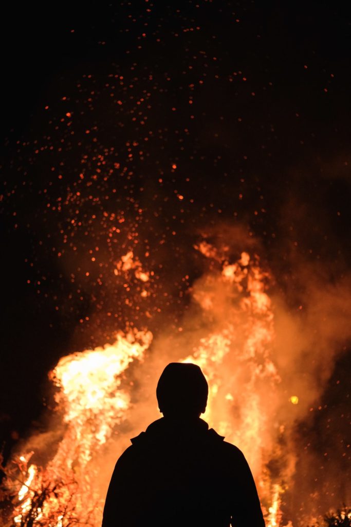 a person standing in front of a fire