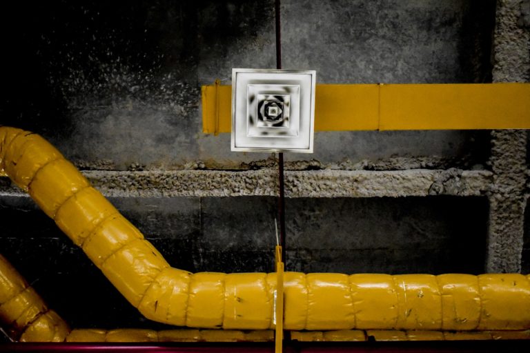 a yellow pipe with a sign on it