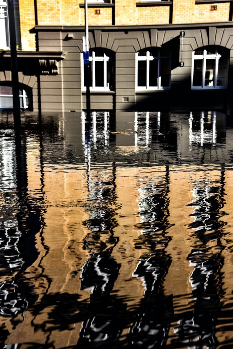 a flooded street with a building and a street light