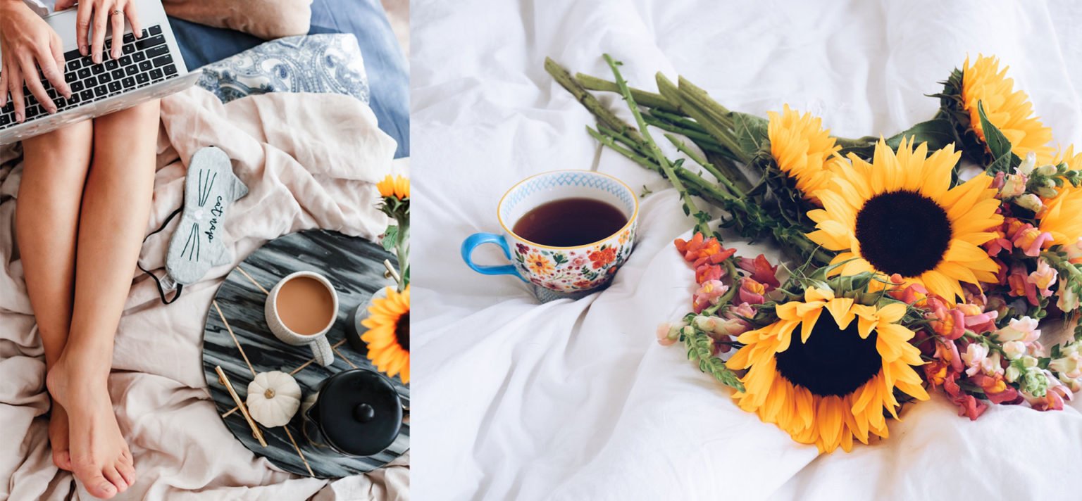 a person sitting next to a table with sunflowers and a cup of coffee