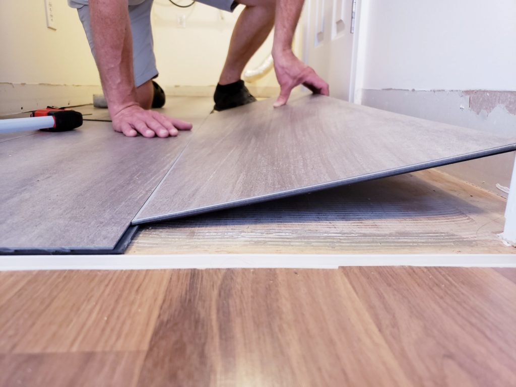 a person's feet on a mat on a wood floor