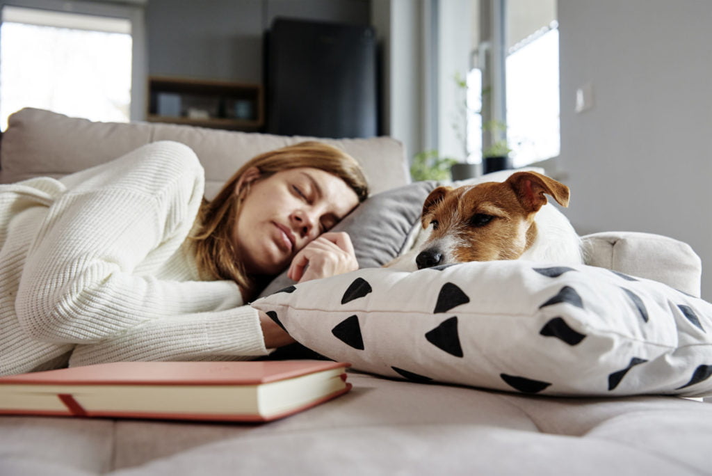 WOMAN SLEEPING NEXT TO HER DOG