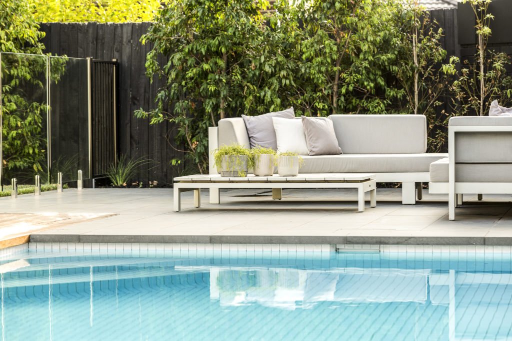 a pool with a couch and a table in the background