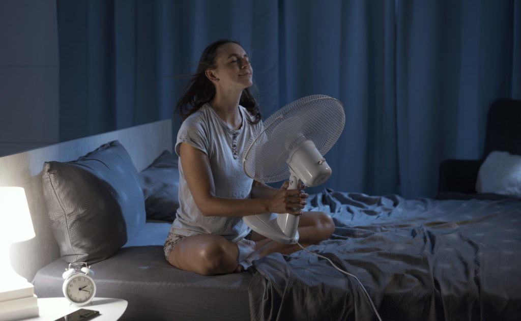 Woman enjoying fresh air in front of a fan