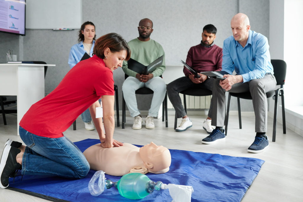 Female instructor showing CPR on training doll