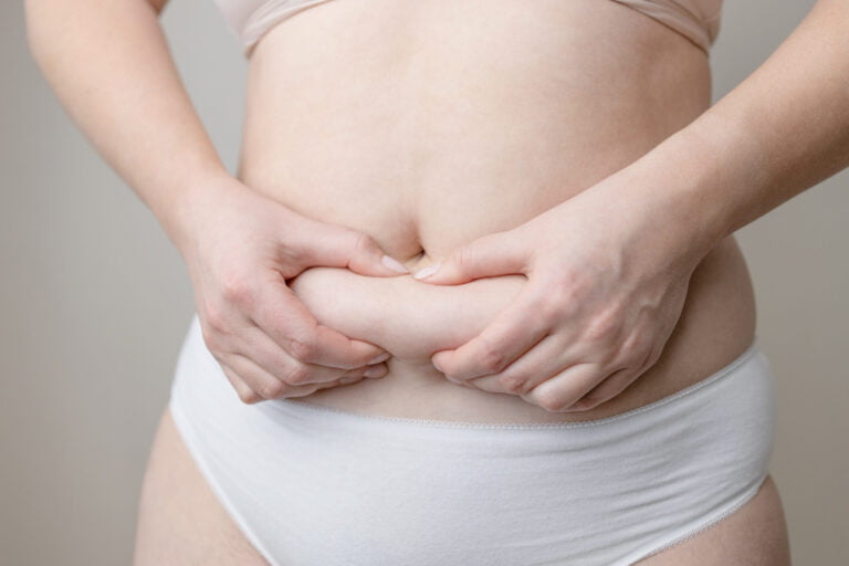 wellness, fat woman hand holding fat belly utc scaled